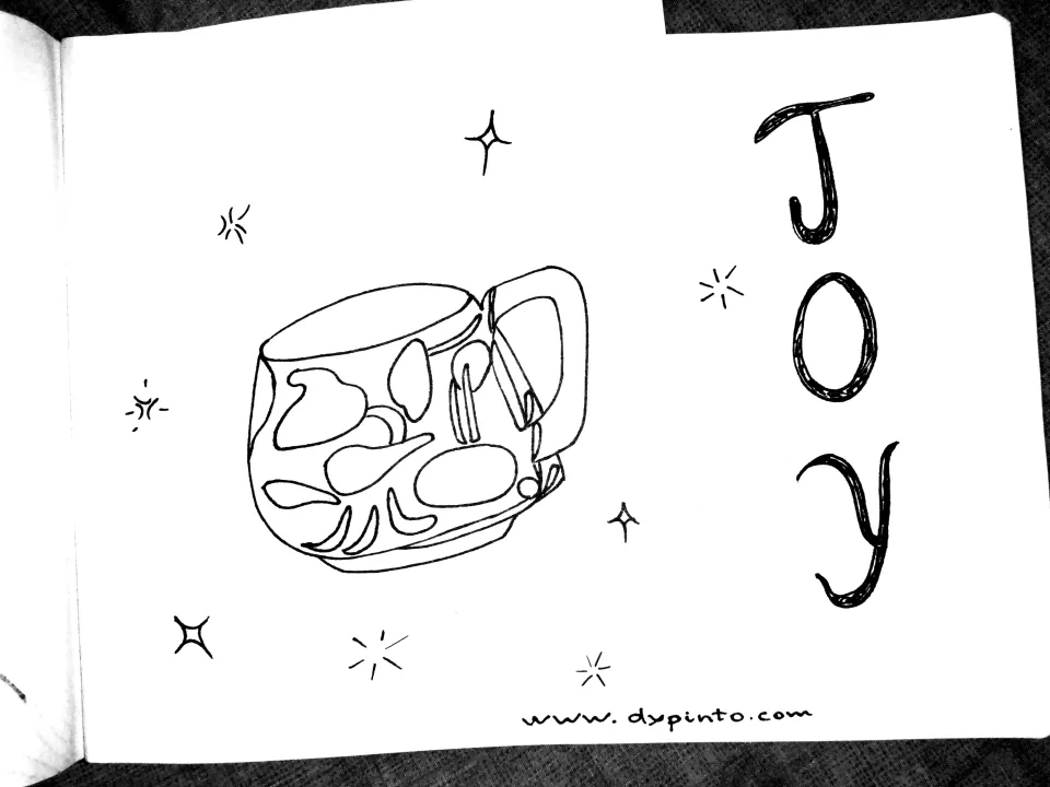 an illustration of an artsy cup with sparks, stars and the word Joy